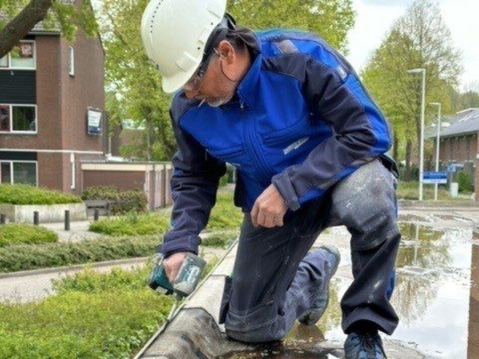 Een medewerker op het dak van de garage
