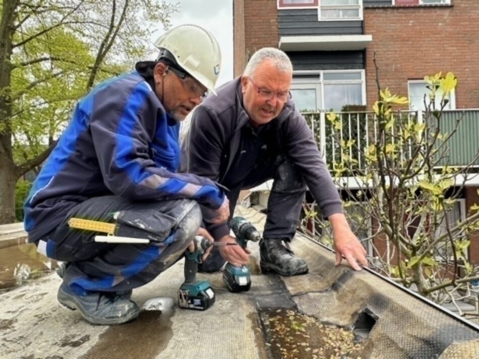 Twee onderhoudsmonteurs op het dak van de garage