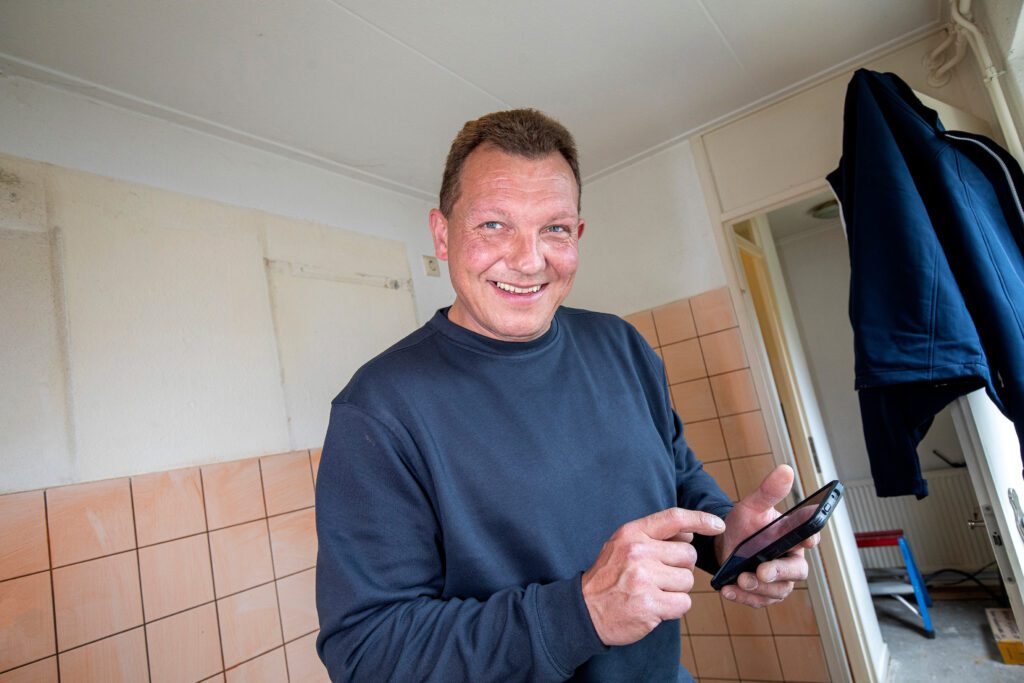 Man die op mobiele telefoon kijkt