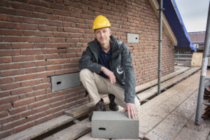 Bas Otten bij de gevel met ingebouwde nestkasten voor huismussen en gierzwaluwen
